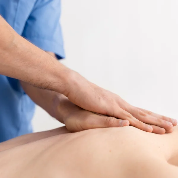 Un homme reçoit un massage du dos dans une salle dédiée à la récupération musculaire.