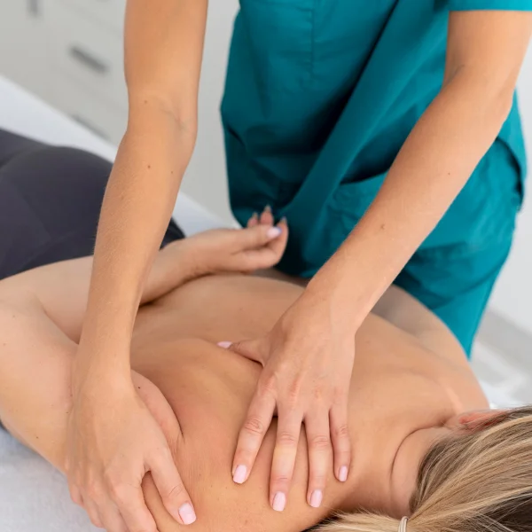 Une femme reçoit un massage du dos dans un hôpital pour favoriser sa récupération musculaire.