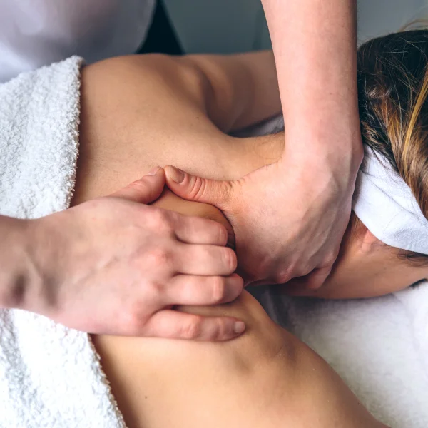 Une femme reçoit un massage du dos dans un spa pour soulager sa tension musculaire.